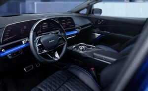Interior del Cadillac OPTIQ-V 2026 con volante V-Series, pantalla curva de 33 pulgadas y acabados en fibra de carbono