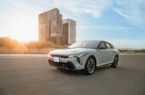 Kia K4 sedán compacto circulando en ciudad al atardecer, modelo ganador del premio Drivers Choice 2026 de MotorWeek