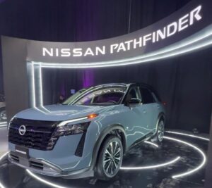 Nissan Pathfinder 2026 en color arena con fondo arquitectónico y branding de EnRuta